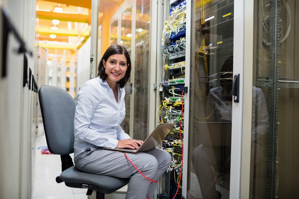 Portrait of technician working on laptop in server room Portrait of technician working on laptop in server room